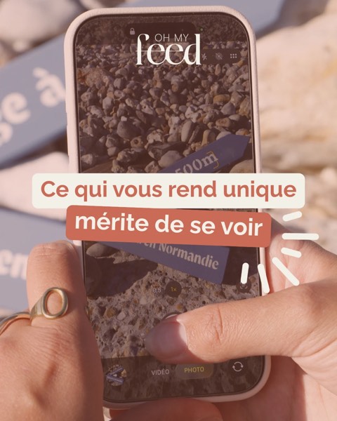 Smartphone en main photographiant des galets, avec le texte « Ce qui vous rend unique mérite de se voir ».