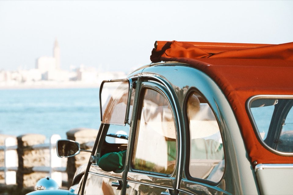 2CV garée face à la mer, avec la ville du Havre en fond.