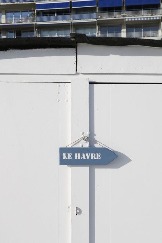 Pancarte « Le Havre » fixée sur une cabane de plage blanche.