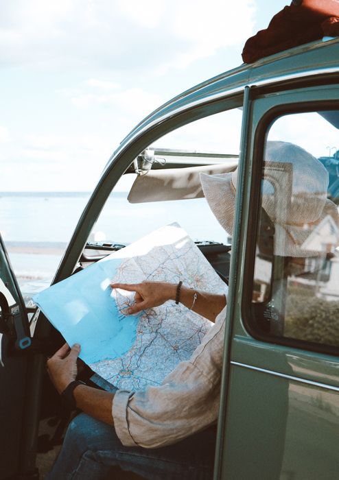 Passagère lisant une carte routière dans une 2CV.