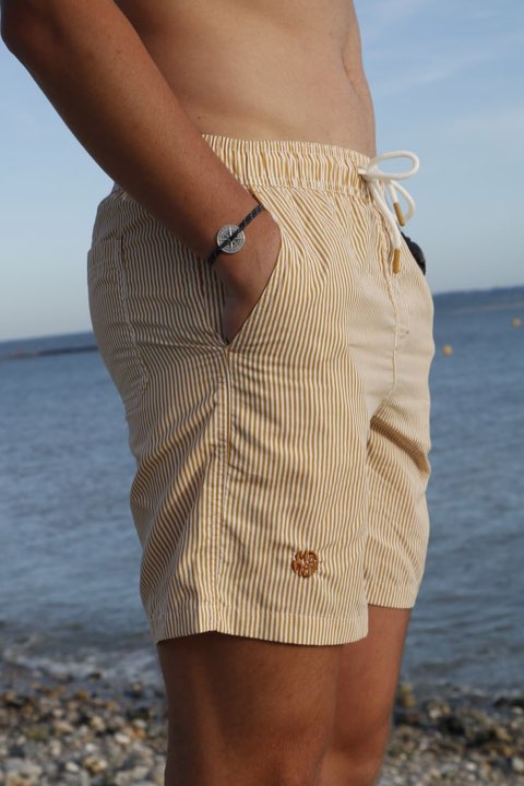 Short de bain rayé porté au bord de la mer.